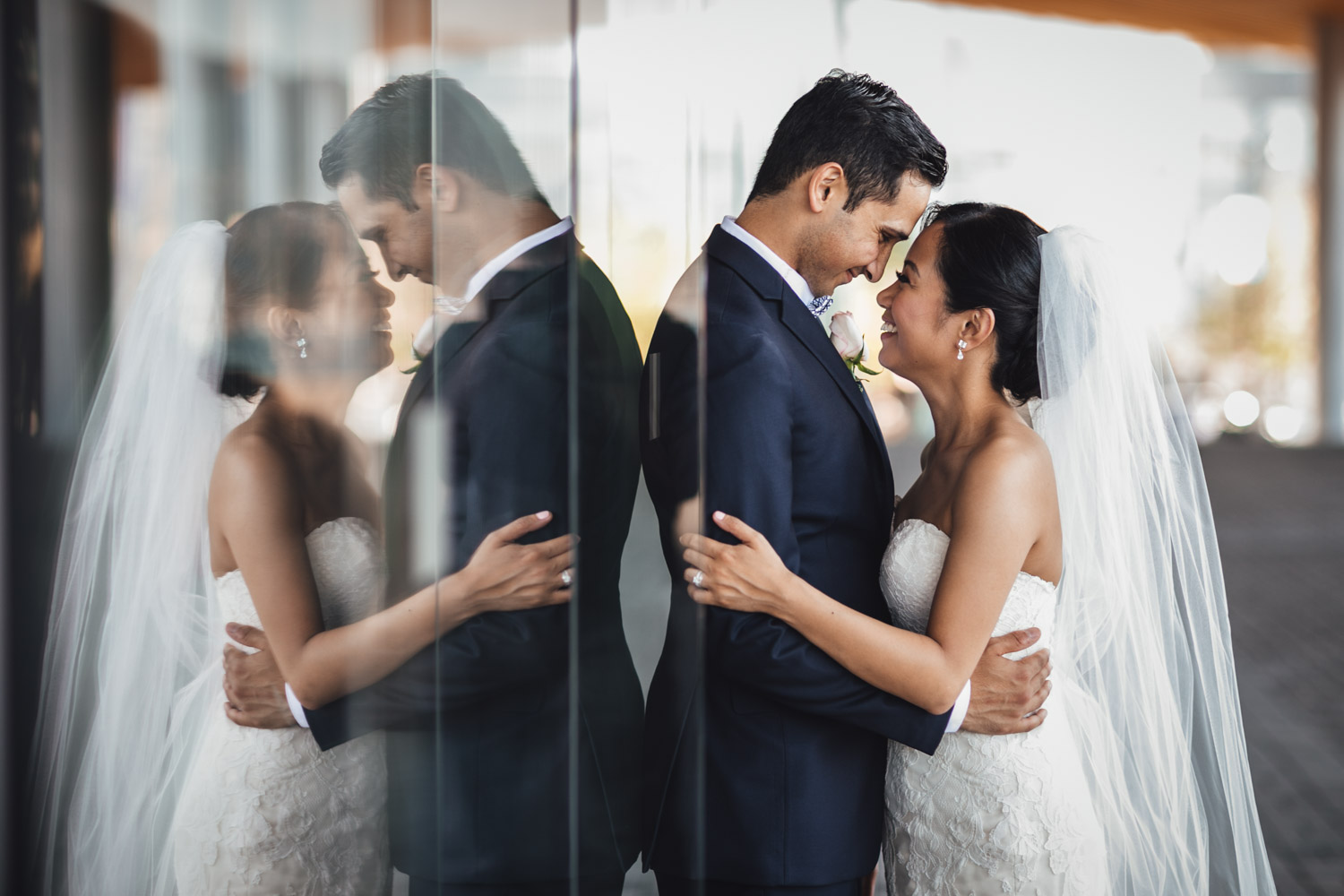 bride and groom glass reflection at convention centre in vancouver bc