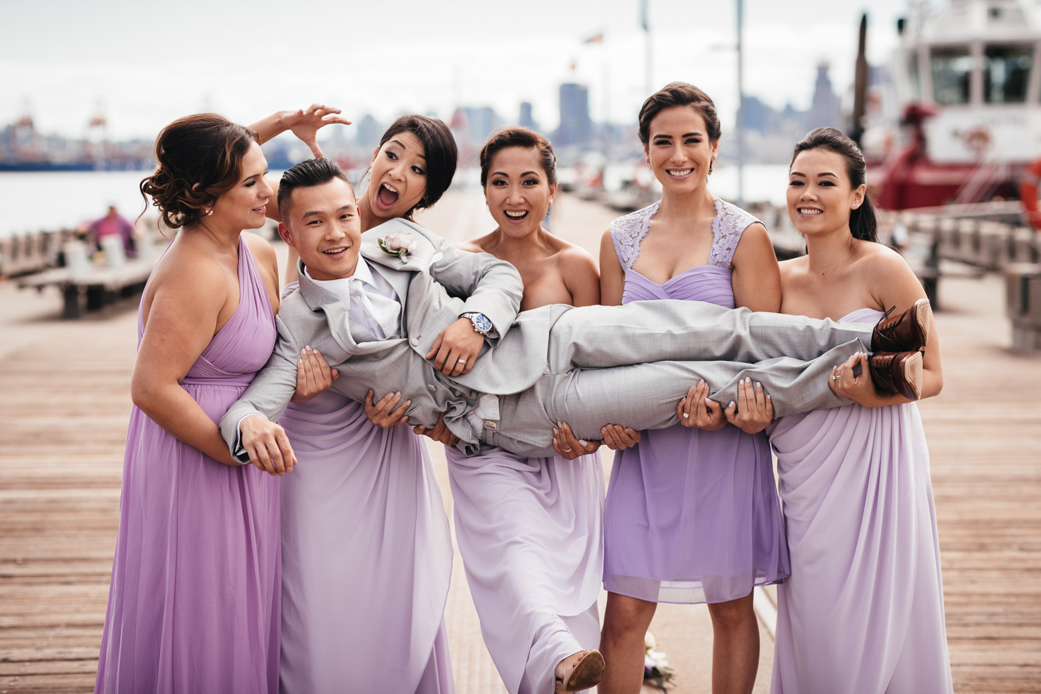 groom with bridesmaids in north vancouver for wedding at burrard dry dock pier